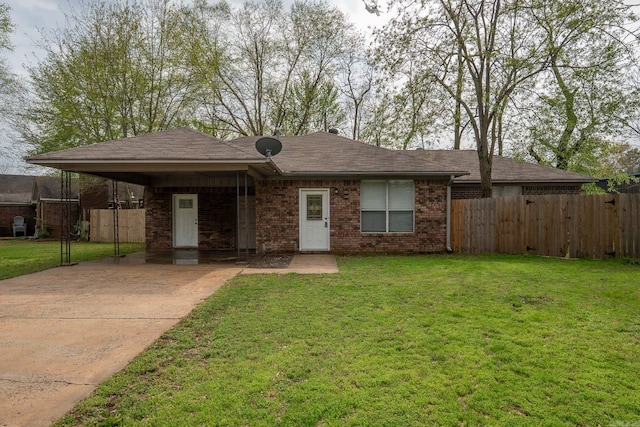 view of front of home featuring an attached carport, a front yard, fence, and concrete driveway