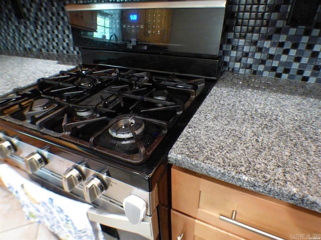 302 Veranda, Pearcy, AR 71964 - interior details featuring stone countertops, stainless steel gas range, brown cabinetry, and decorative backsplash
