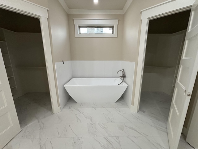 228 Michelle Dr, Beebe, AR 72012 - bathroom featuring a spacious closet, a freestanding tub, marble look tile flooring, ornamental molding, and a wainscoted wall
