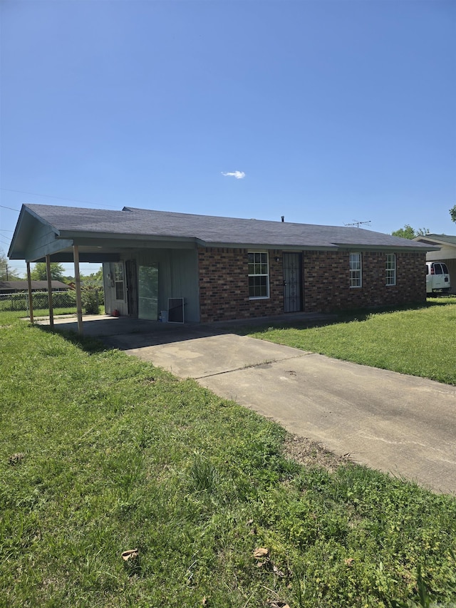 view of front of home with an attached carport, a front yard, brick siding, and driveway