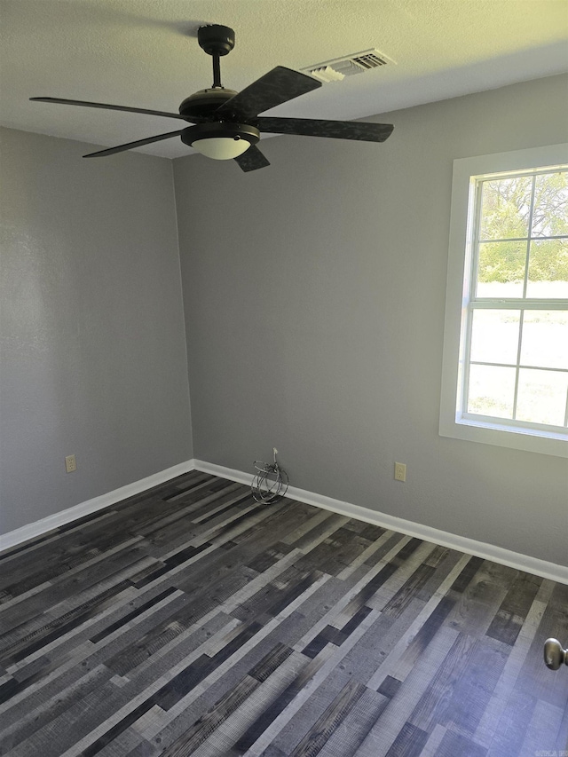 empty room with visible vents, baseboards, a ceiling fan, and a textured ceiling