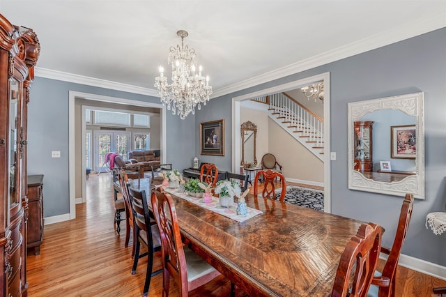 dining area featuring crown molding, stairway, an inviting chandelier, and wood finished floors