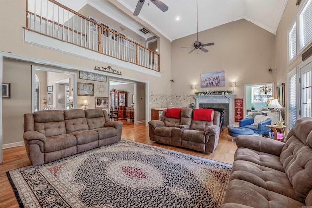 living area featuring wood finished floors, baseboards, a ceiling fan, and visible vents