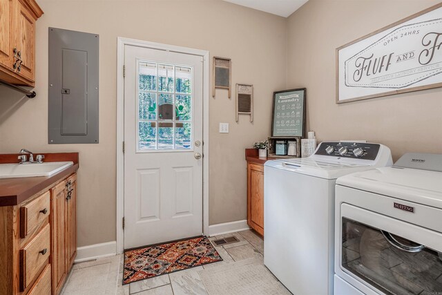 laundry room with baseboards, electric panel, a sink, cabinet space, and washer and clothes dryer