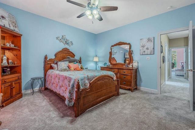 bedroom featuring baseboards, a ceiling fan, and light colored carpet