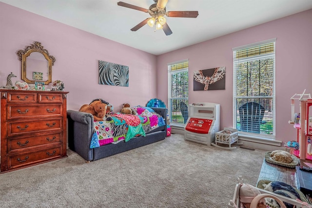 carpeted bedroom featuring ceiling fan and multiple windows