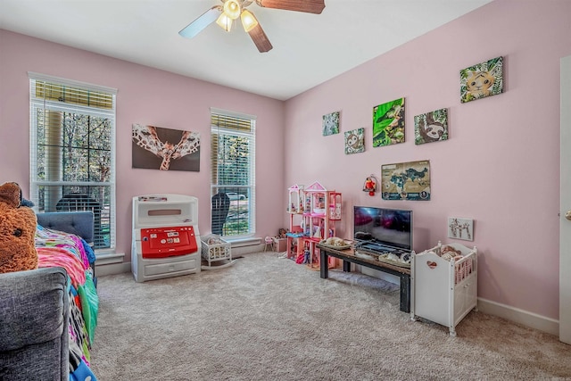 recreation room with a healthy amount of sunlight, baseboards, a ceiling fan, and carpet floors