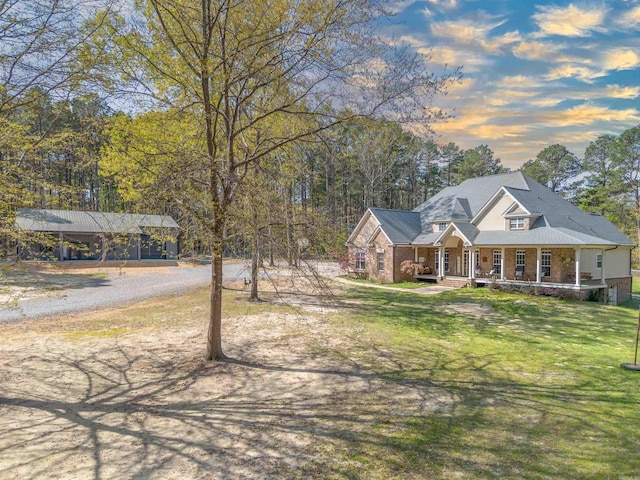 view of front of house featuring a front yard, a porch, and dirt driveway