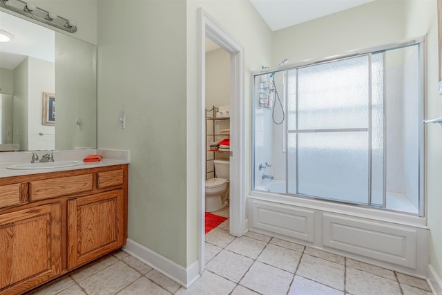 bathroom with tile patterned flooring, toilet, vanity, and baseboards