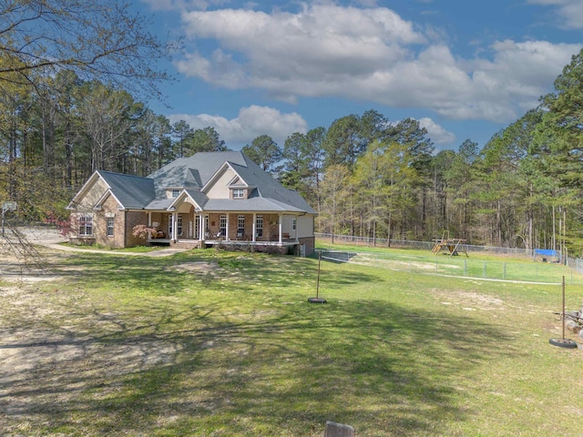 view of front of property with brick siding, fence, a front lawn, and covered porch