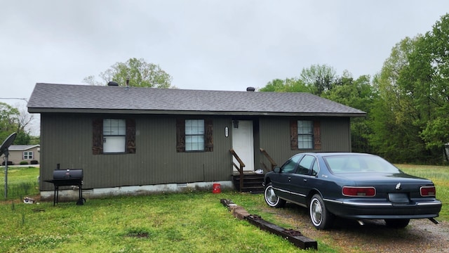 view of front of home featuring entry steps, a front yard, crawl space, and roof with shingles