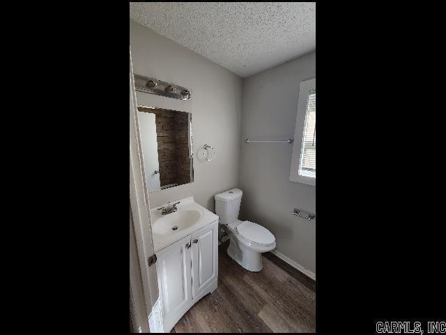5507 Southboro Ct, Little Rock, AR 72209 - half bath with toilet, vanity, wood finished floors, and a textured ceiling