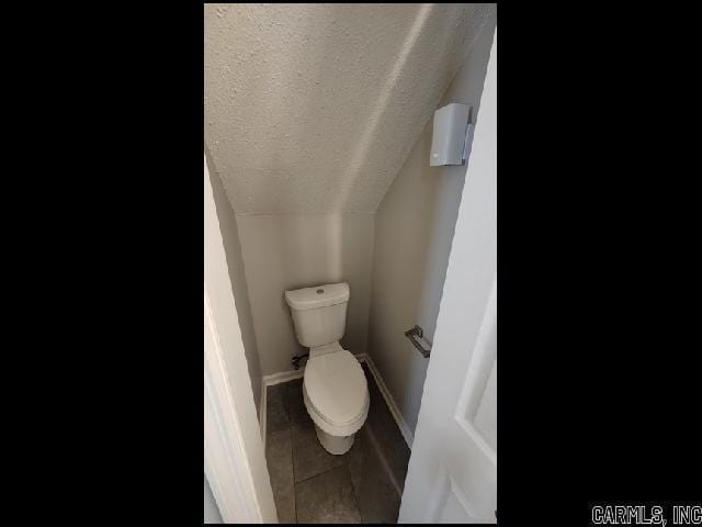 5507 Southboro Ct, Little Rock, AR 72209 - bathroom with baseboards, toilet, a textured ceiling, tile patterned flooring, and lofted ceiling