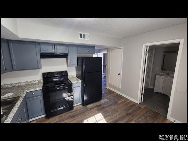 5507 Southboro Ct, Little Rock, AR 72209 - kitchen featuring dark wood-type flooring, a textured ceiling, visible vents, black appliances, and under cabinet range hood
