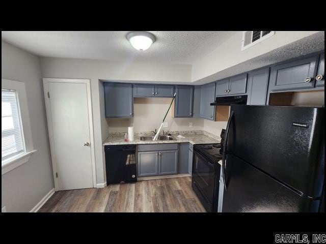 5507 Southboro Ct, Little Rock, AR 72209 - kitchen featuring a textured ceiling, black appliances, under cabinet range hood, light countertops, and a sink