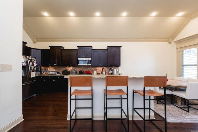 3 Commentry Dr, Little Rock, AR 72223 - kitchen with black fridge, a kitchen breakfast bar, dark wood finished floors, stainless steel microwave, and lofted ceiling