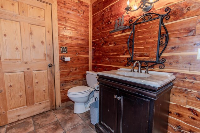 208 Mountain Dr, Perryville, AR 72126 - bathroom with tile patterned flooring, wooden walls, vanity, and toilet