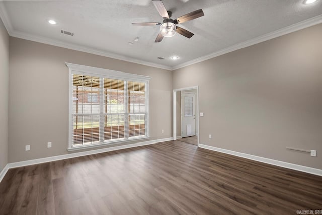 spare room featuring crown molding, ceiling fan, baseboards, and dark wood finished floors