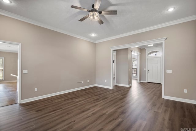 empty room featuring dark wood-type flooring, crown molding, and ceiling fan