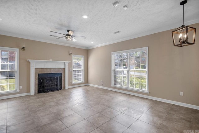 unfurnished living room with visible vents, baseboards, a fireplace, crown molding, and ceiling fan with notable chandelier