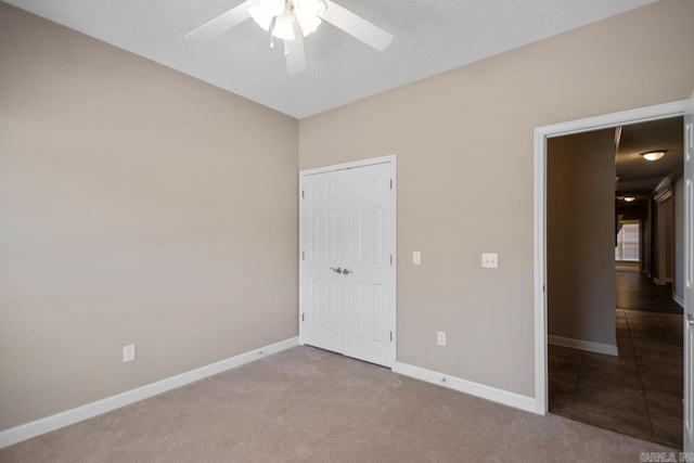 unfurnished bedroom featuring carpet flooring, baseboards, and a ceiling fan