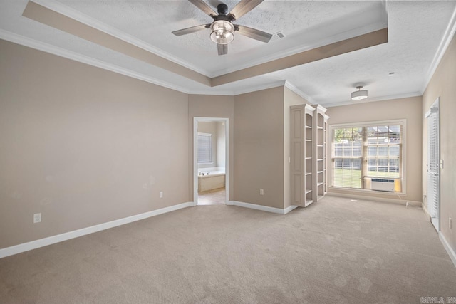 unfurnished room featuring a tray ceiling, baseboards, a ceiling fan, and light colored carpet