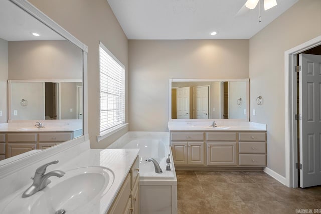 bathroom with two vanities, a garden tub, and a sink
