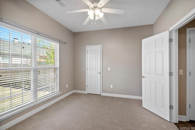 unfurnished bedroom featuring a ceiling fan, baseboards, carpet, and visible vents