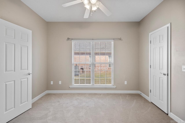 unfurnished bedroom with light carpet, baseboards, and ceiling fan