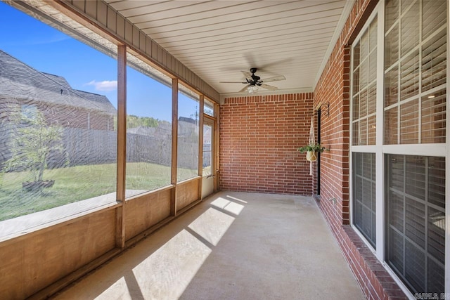 unfurnished sunroom featuring a ceiling fan