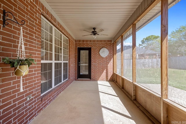 unfurnished sunroom featuring a ceiling fan