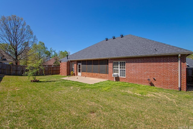 back of property with a patio area, a fenced backyard, brick siding, and a yard