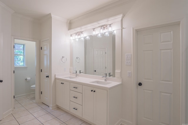 full bathroom with toilet, double vanity, a sink, and ornamental molding