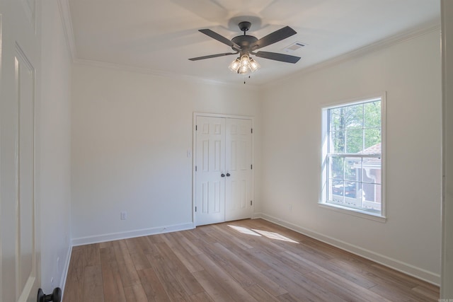 unfurnished room with baseboards, crown molding, light wood-style floors, visible vents, and ceiling fan