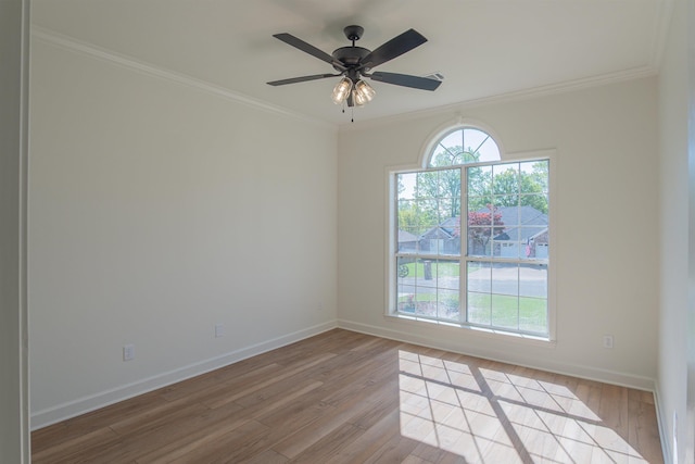 spare room featuring light wood finished floors, baseboards, and ornamental molding