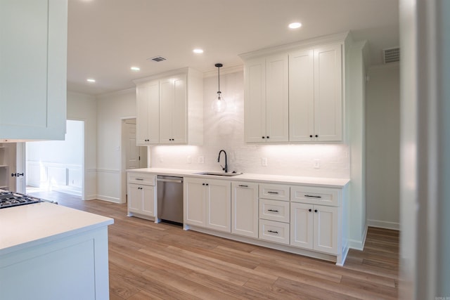 kitchen featuring visible vents, dishwasher, a sink, light countertops, and light wood-style flooring