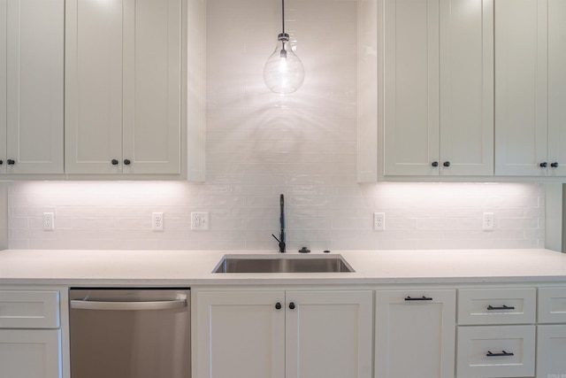 kitchen featuring light countertops, white cabinets, decorative backsplash, dishwasher, and a sink