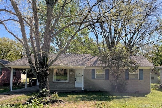 ranch-style house featuring brick siding, a front yard, a shingled roof, and an attached carport