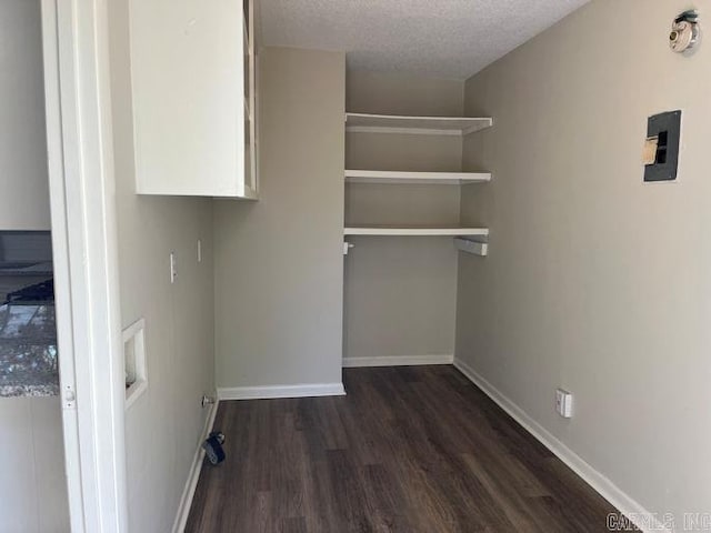 washroom featuring baseboards, dark wood-style floors, laundry area, and a textured ceiling