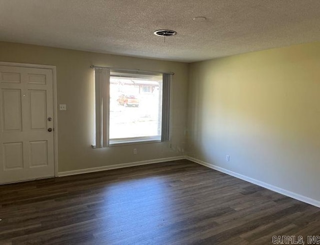 foyer entrance with dark wood-type flooring, baseboards, and a textured ceiling