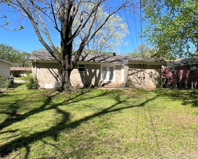 exterior space featuring brick siding, french doors, and a lawn