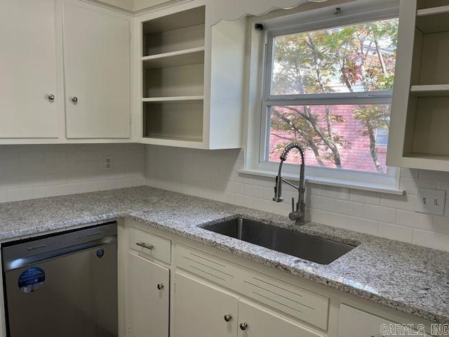 kitchen featuring white cabinetry, backsplash, open shelves, stainless steel dishwasher, and a sink