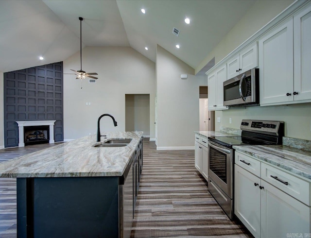 341 Diamondhead Dr, Hot Springs, AR 71913 - kitchen with a ceiling fan, appliances with stainless steel finishes, light stone counters, a sink, and a center island with sink