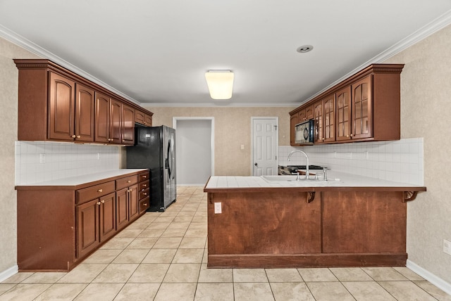kitchen with stainless steel refrigerator with ice dispenser, a sink, a peninsula, black microwave, and light tile patterned flooring