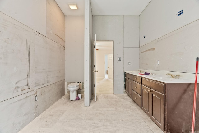 bathroom featuring toilet, double vanity, and a sink