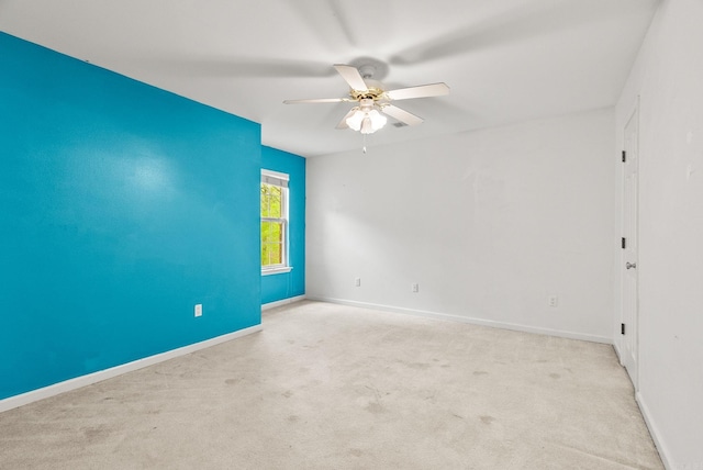 spare room featuring carpet floors, ceiling fan, and baseboards