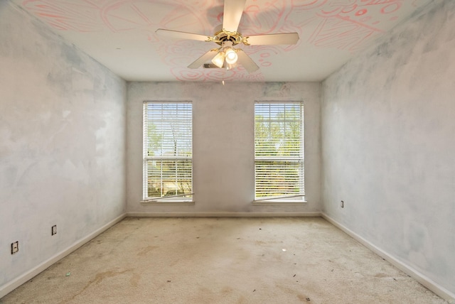 carpeted empty room with ceiling fan, baseboards, and a healthy amount of sunlight