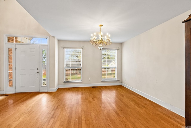 entrance foyer featuring baseboards, light wood-type flooring, and a chandelier