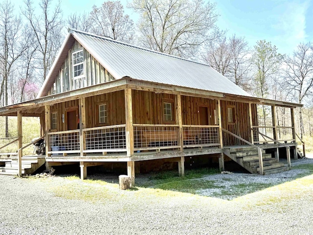 view of front of property with board and batten siding, covered porch, and metal roof