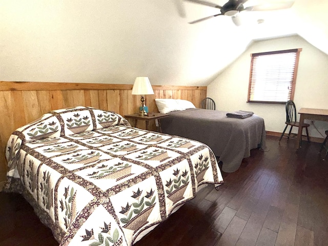 bedroom featuring dark wood-type flooring, wooden walls, a ceiling fan, and vaulted ceiling